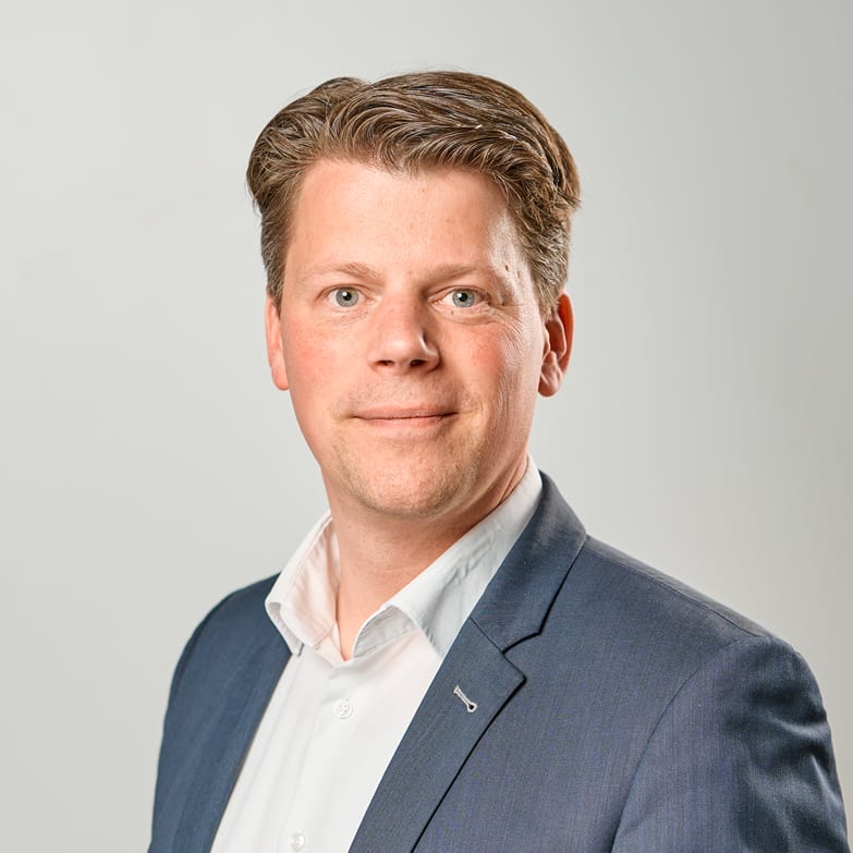 business professional portrait, smiling man in formal attire with blue suit and white shirt against neutral background