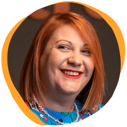 smiling woman with red hair in colorful dress, bright background with soft edges and cheerful expression
