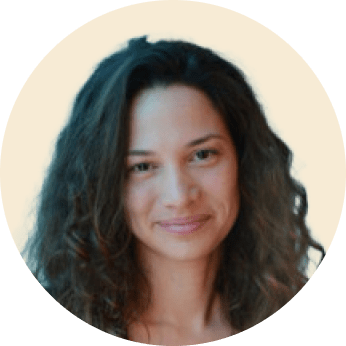 woman with curly hair in a circular frame, smiling softly against a light background, portrait of a smiling woman with textured hair